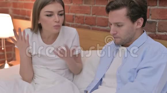 愤怒的年轻夫妇在床上争吵视频的预览图