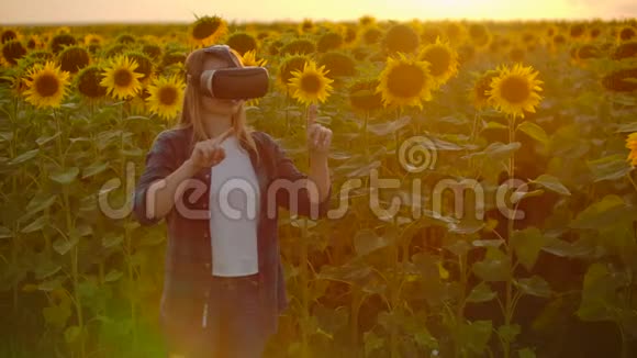 现代女性农民在一个有向日葵的田野使用VR技术模拟应用程序用户界面控制视频的预览图