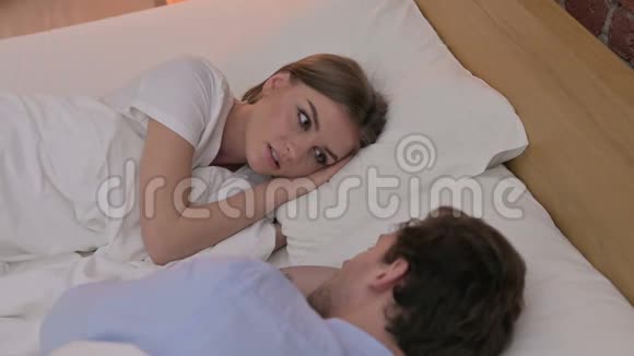 后景年轻夫妇在床上交谈视频的预览图