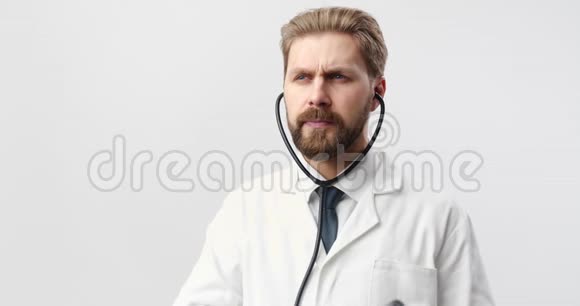 使用听诊器穿白色制服的成熟胡须医生视频的预览图