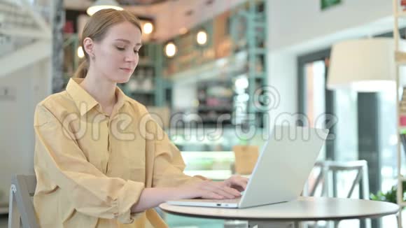 年轻女子在咖啡厅用手提电脑视频的预览图