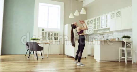 年轻健康的女人练习健身瑜伽站在家里的桥牌姿势视频的预览图