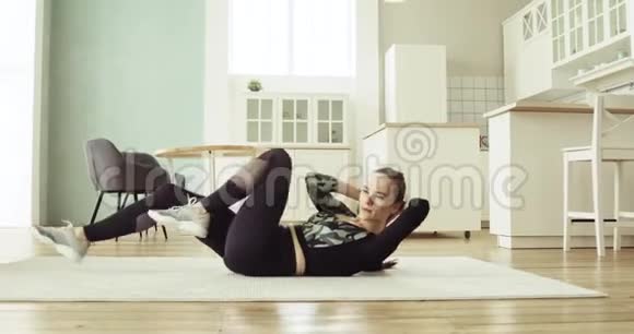 女人正在家里的地板上做腹部运动视频的预览图