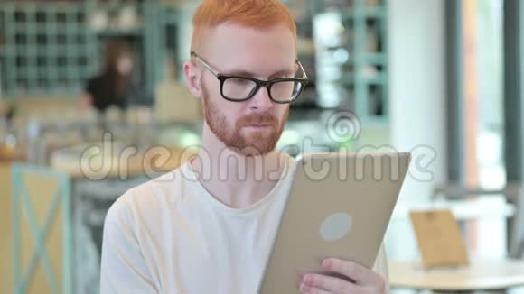 使用数码平板电脑的职业红发男子画像视频的预览图