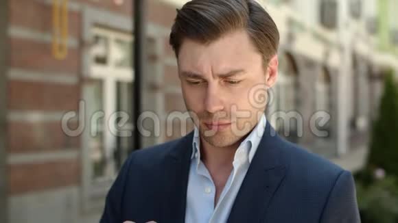 特写男在街上拿着现代触摸板男人在平板电脑上浏览互联网视频的预览图