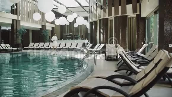 帅哥在酒店靠近游泳池健身男子放松附近的水疗池视频的预览图