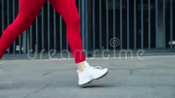 在街上慢跑时把女跑步者的腿收起来女子近距离训练视频的预览图