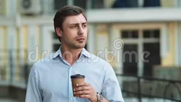 特写商人在街上喝咖啡看着街边的男人视频的预览图