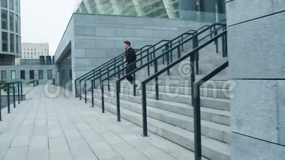 体育健将从户外楼梯上跑下来健身男子训练运动视频的预览图