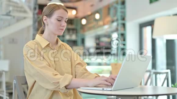 青年妇女在咖啡厅镜头前微笑使用笔记本电脑视频的预览图
