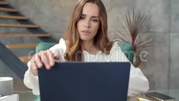 精疲力竭的商务女性在工作场所放松女性自由职业者关闭手提电脑视频的预览图