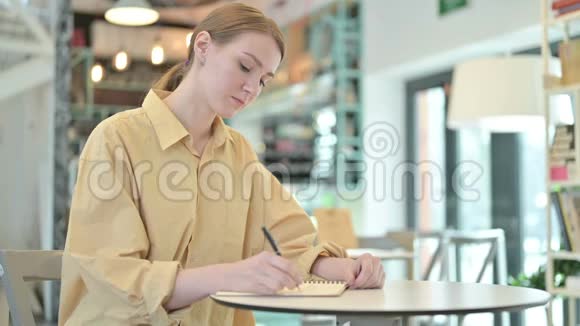 女青年在咖啡厅做文书工作视频的预览图