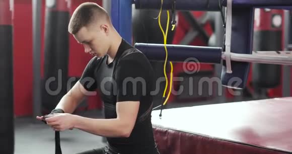 年轻的拳击手在拳击或健身房训练前包扎绷带视频的预览图