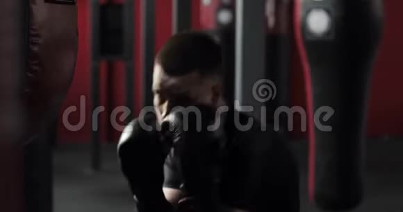 好斗的拳击手年轻男子手套拳击和在健身房看相机视频的预览图