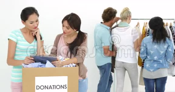 微笑工人团队在捐款箱旁使用平板电脑视频的预览图