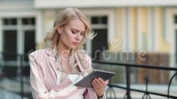 商业女性在街头工作时使用触摸板在外面工作的女孩视频的预览图