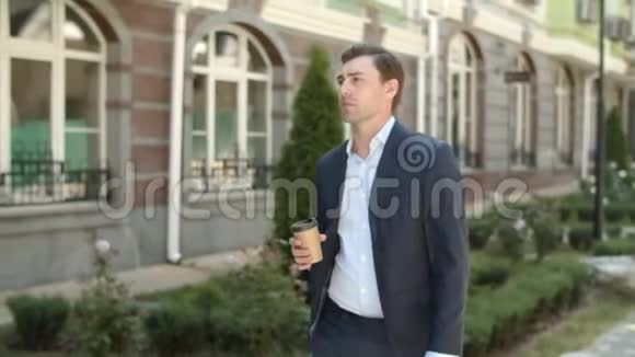 贴身男带着咖啡在户外散步男人下班前喝咖啡视频的预览图