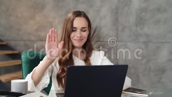 微笑商务女士在笔记本电脑上做电话会议女同事的笔记本电脑视频的预览图