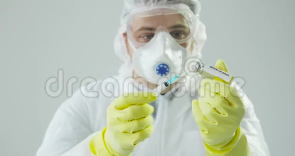 肖像医生用冠状病毒疫苗填充注射器准备注射视频的预览图