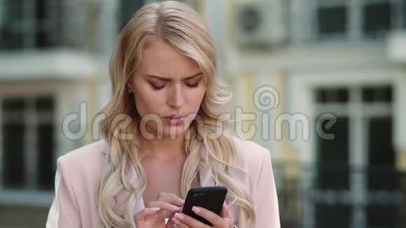 肖像严肃的女商人使用智能手机户外女人打电话视频的预览图