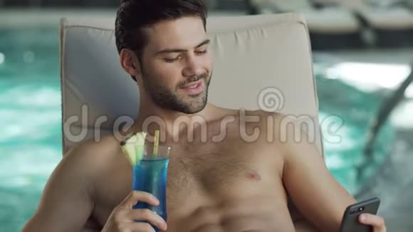近距离性感男人在泳池边用电话放松快乐的人在移动视频的预览图