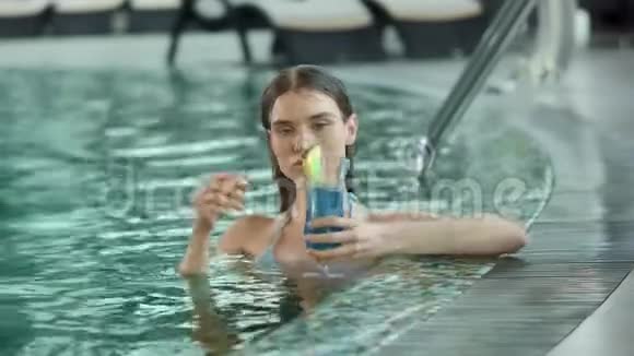 在游泳池喝鸡尾酒的性感女人的肖像喝鸡尾酒的湿漉漉的女孩视频的预览图