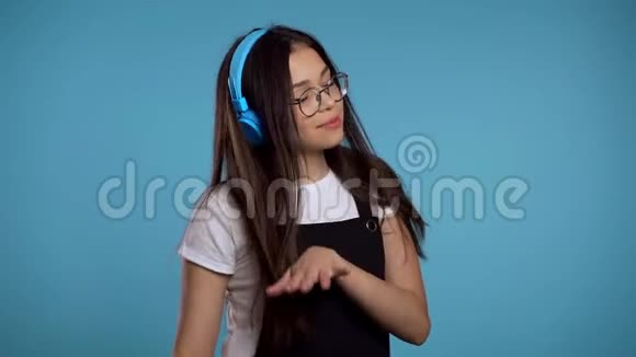 年轻漂亮的亚洲女孩在演播室里带着耳机跳舞开心地笑着视频的预览图