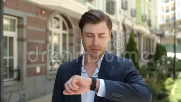 户外使用智能手表的肖像人在街上看着智能手表的人视频的预览图