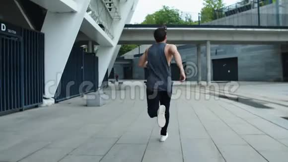 城市街道上跑步的运动型男子的后视图运动员在户外慢跑视频的预览图
