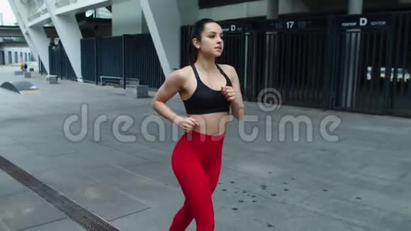 在城市街道上跑步的年轻女运动员在户外慢跑时调情的性感女人视频的预览图