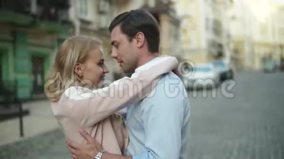 可爱的情侣在街上拥抱男人和女人站在户外视频的预览图