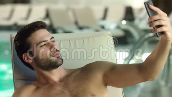 特写性感男人在游泳池附近自拍帅哥表现得像个手势视频的预览图