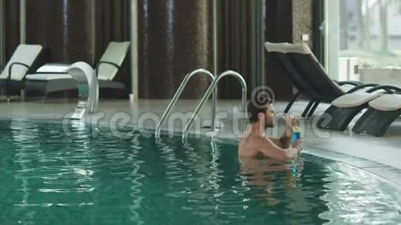 有魅力的男人在豪华游泳池喝鸡尾酒喝酒放松的家伙视频的预览图