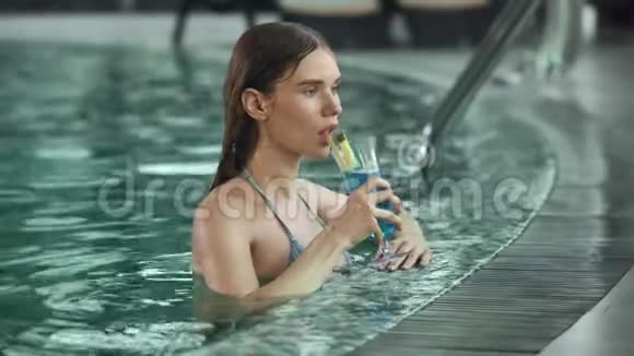 近距离性感的女人在游泳池度假喝鸡尾酒女人在泳池里调情视频的预览图