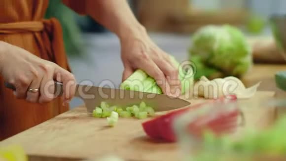 女人手在砧板上切芹菜家庭主妇煮新鲜蔬菜视频的预览图