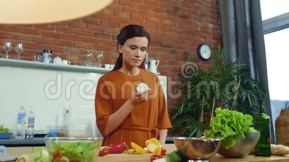 厨房里准备蔬菜沙拉的女孩女人闻着新鲜的洋葱球视频的预览图