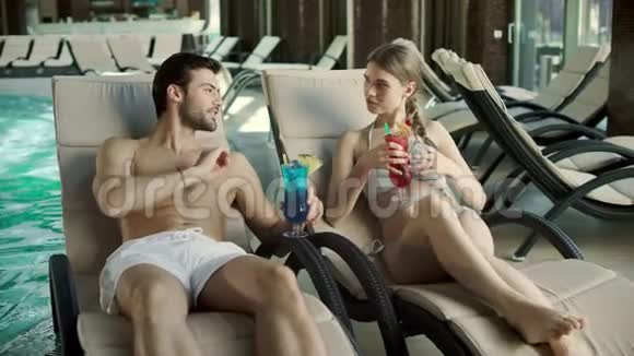 特写情侣在躺椅上喝鸡尾酒男人和女人一起调情视频的预览图