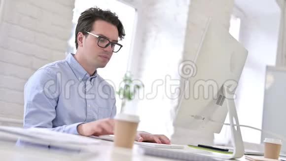 专注工作的年轻人喝咖啡和使用桌面视频的预览图