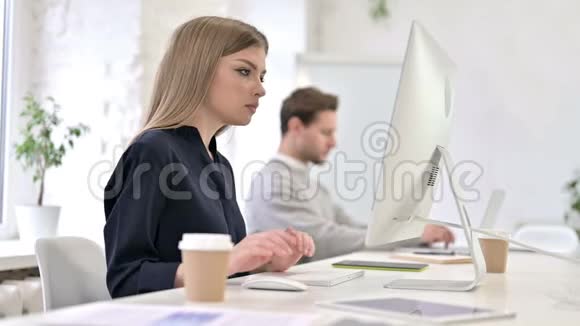 年轻的创意女性在桌面上工作在镜头前微笑视频的预览图
