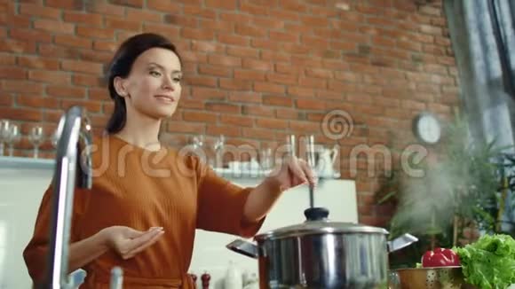 女人在厨房煮健康的食物女孩在煮锅里腌制热饭视频的预览图