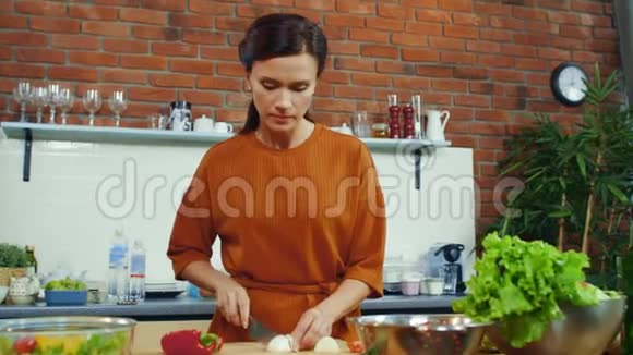 女人品尝切洋葱灯泡微笑的家庭主妇煮蔬菜视频的预览图