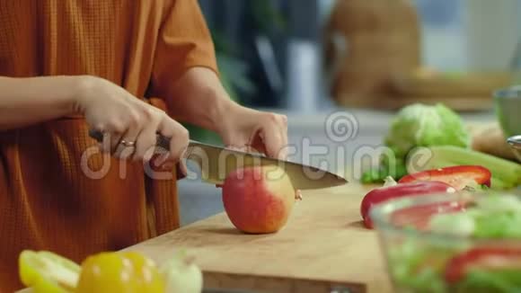 女人在厨房里切红苹果家庭主妇做蔬菜沙拉视频的预览图