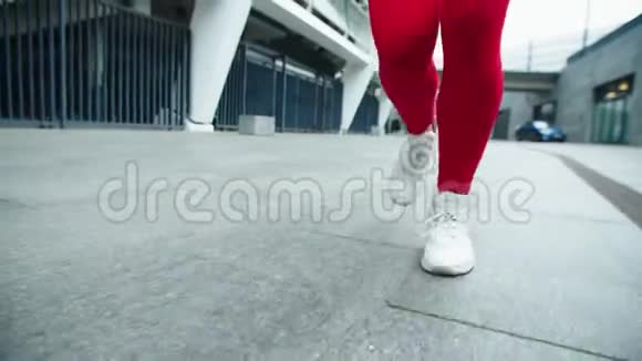 关闭在城市街道上奔跑的女性腿女人的腿在户外慢跑视频的预览图