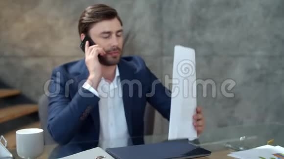 微笑的商人在工作场所打电话快乐的人读文件视频的预览图