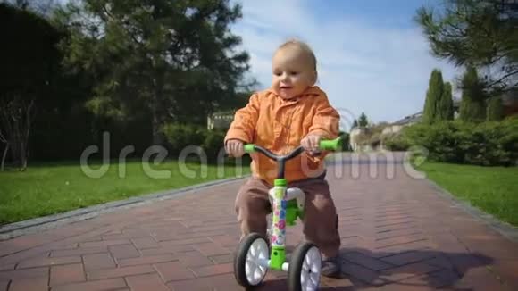 快乐的幼儿骑自行车慢动作微笑的孩子在公园骑自行车视频的预览图