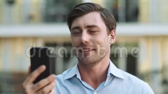 肖像男用手机进行视频聊天商人在外面打视频电话视频的预览图