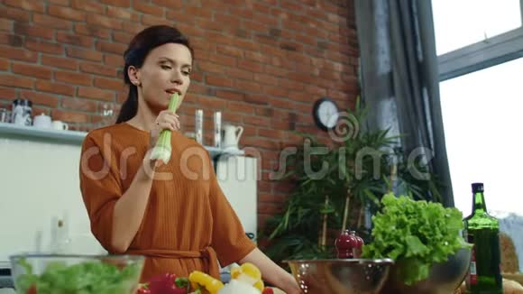 女孩在家吃新鲜芹菜年轻的女人在做饭的时候有了主意视频的预览图
