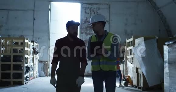 工程师和工头在仓库里谈话视频的预览图