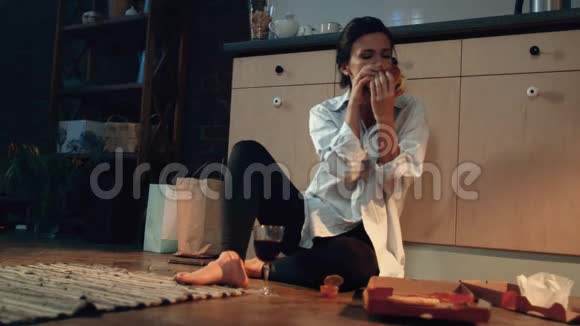饥饿的女人用酒吃汉堡在家吃快餐的女孩视频的预览图