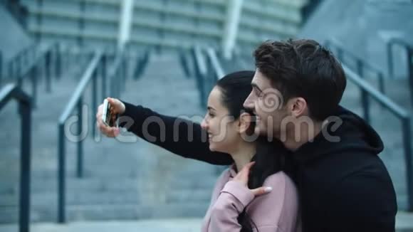 健身夫妇自拍照片到智能手机有趣的情侣摆姿势自拍视频的预览图